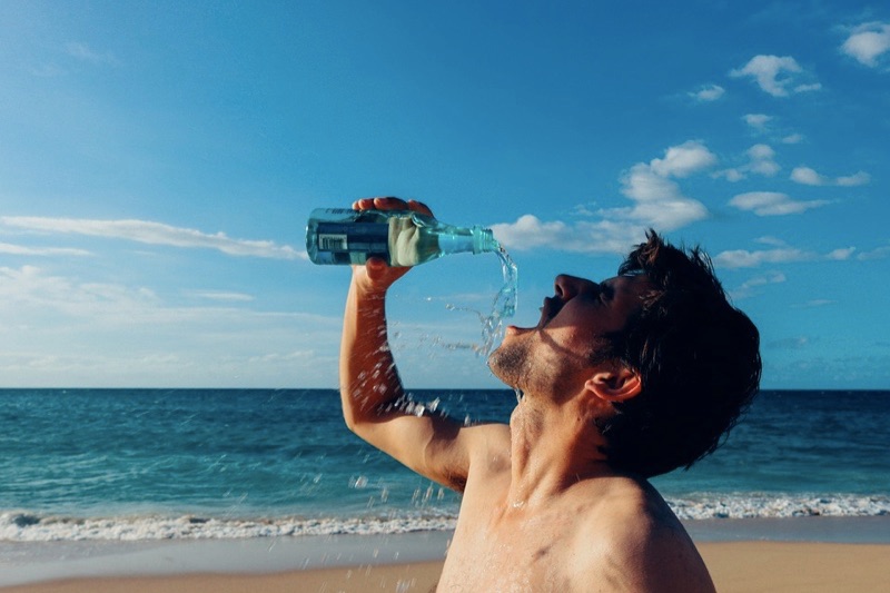 guy-drinking-water-in-beach